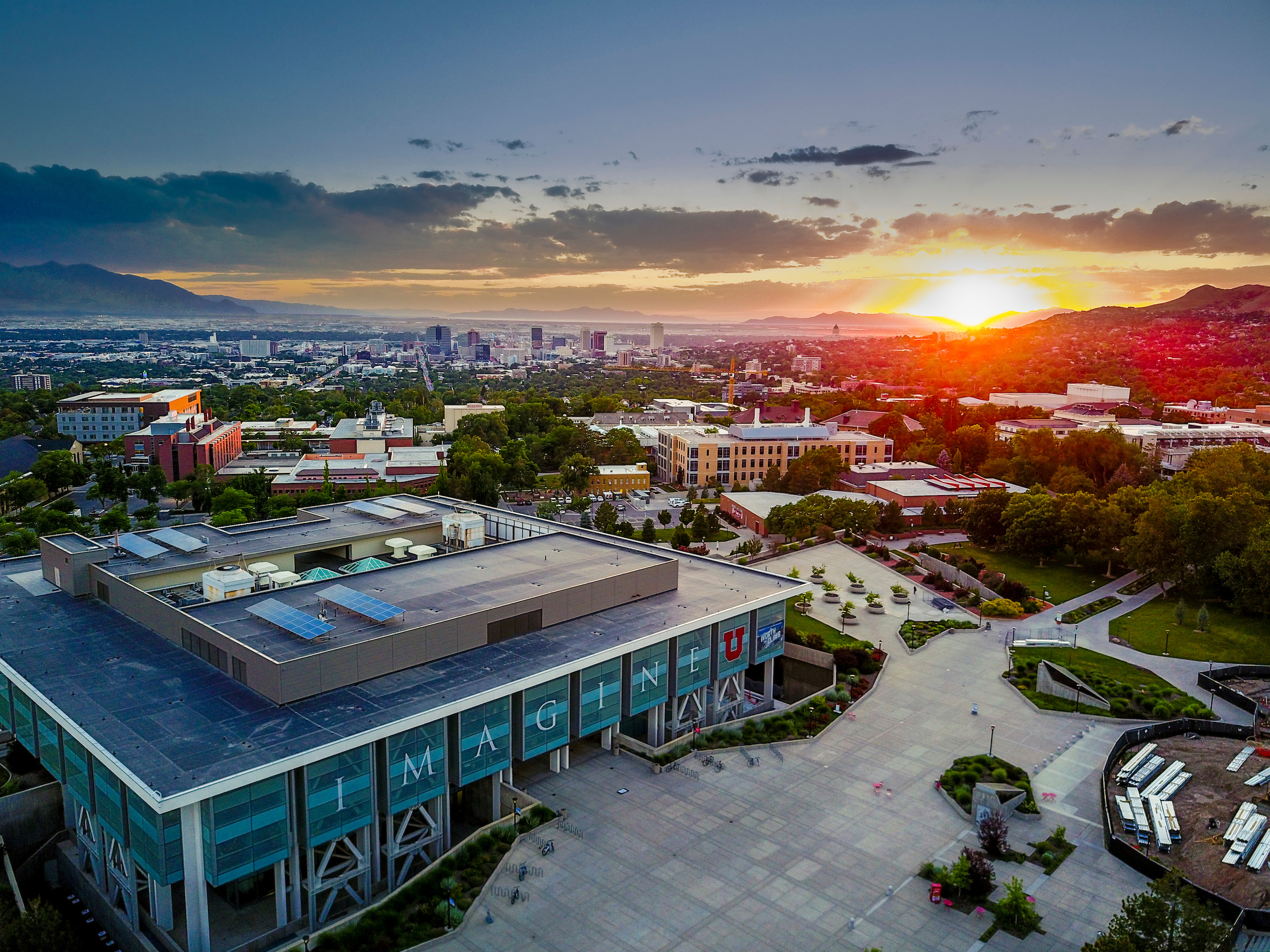 an aerial view of the University of Utah with the sunsetting in the distance
