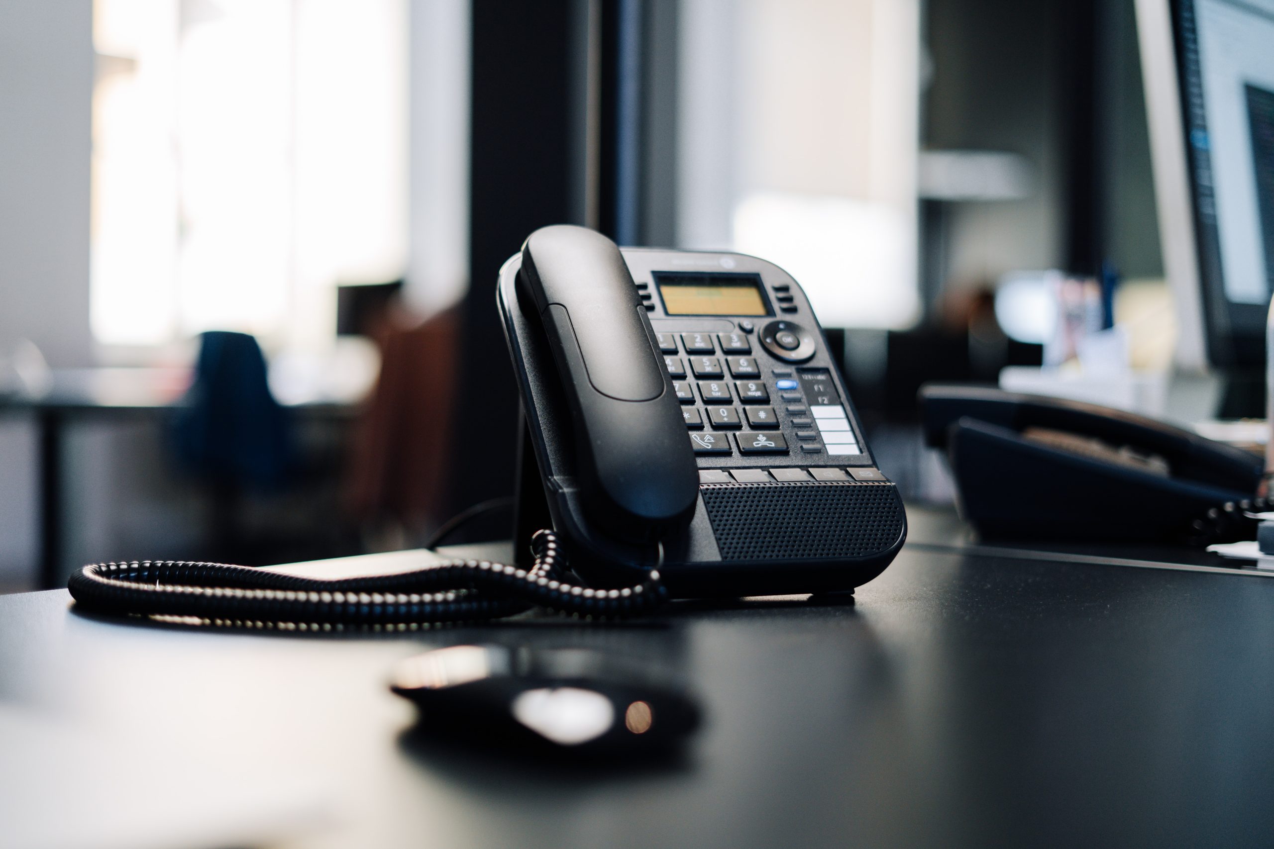 a black office phone on a desk