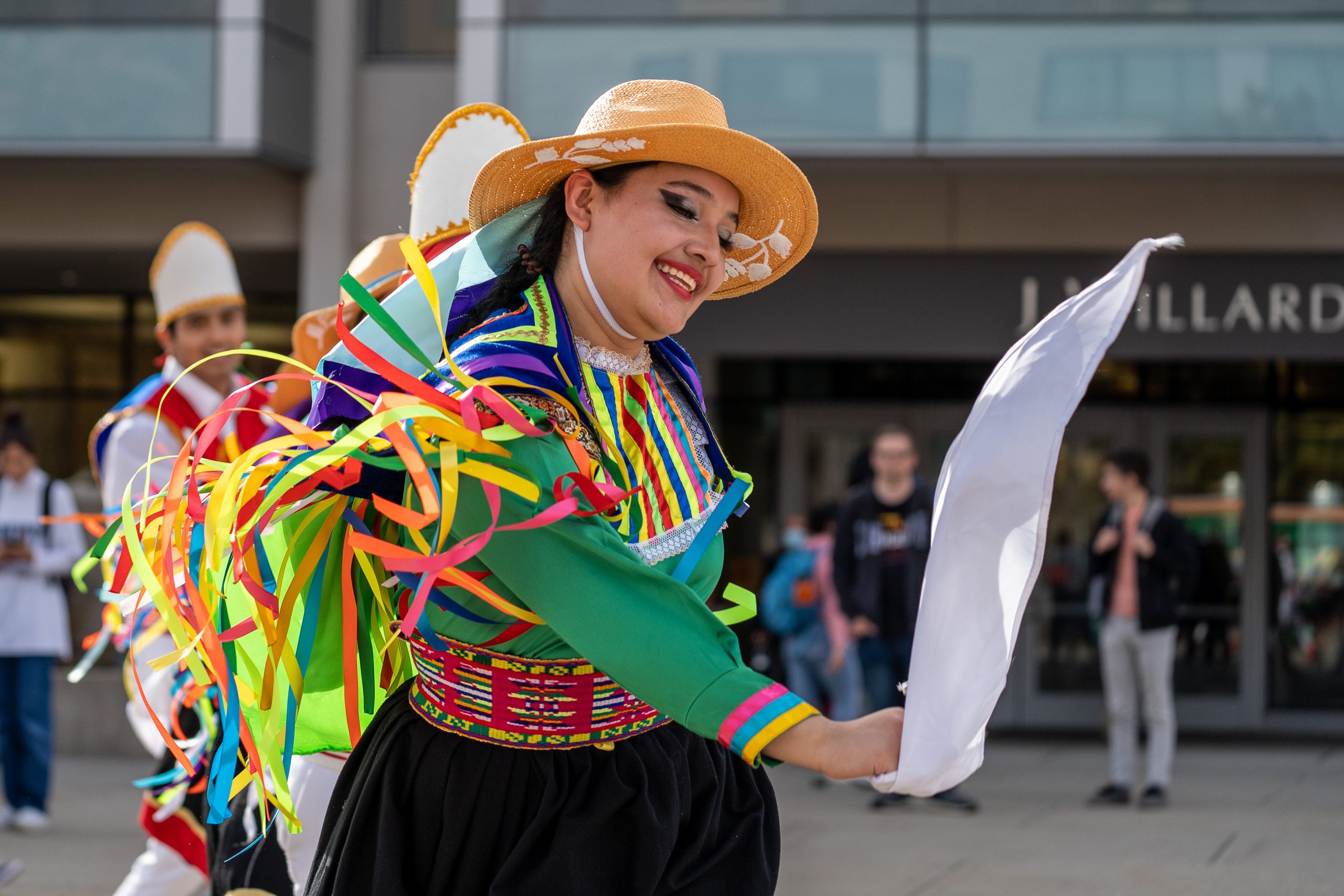 a student dances with a handkerchief while wearing traditional Peruvian clothing
