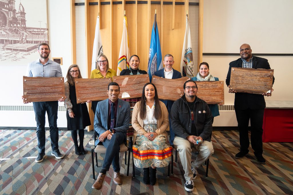 a group of people holding plaques of the Indigenous Land Acknoweldgment