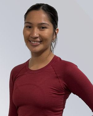 Alyssa smiles in a solid-colored long-sleeve shirt. She has her hair pulled back in a ponytail.