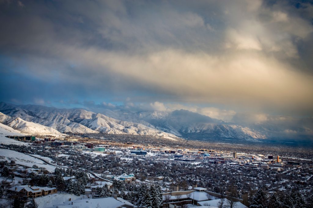 a winter view of the University of Utah campus and the Wasatch mountains in the background covered in snow