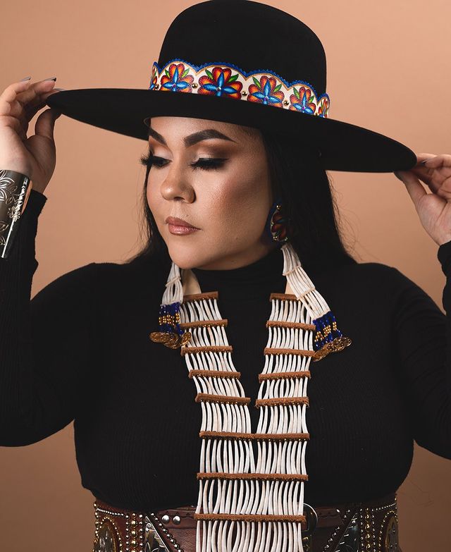 portrait of Fawn Wood wearing Indigenous jewelry and wide brim hat