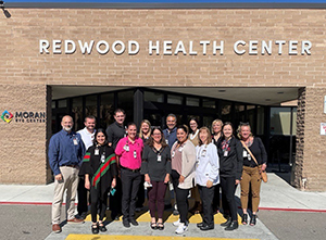 staff of the Redwood Health Center grouped together outside of the clinic